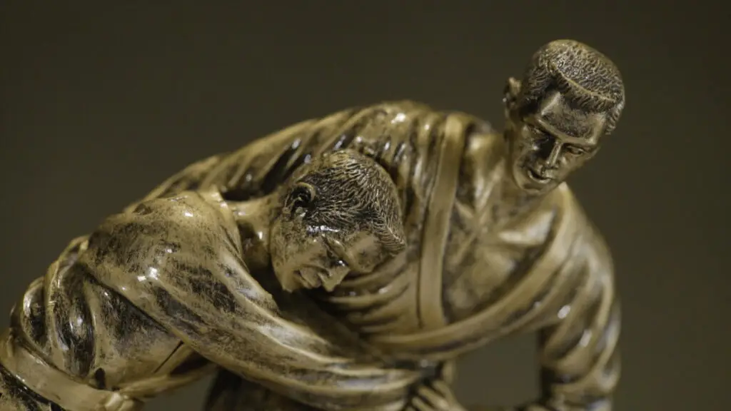 Detailed bronze sculpture of two judo practitioners engaged in a throw technique, with one athlete redirecting the other's force—visual metaphor for leadership judo move that redirects problems back to team members for ownership