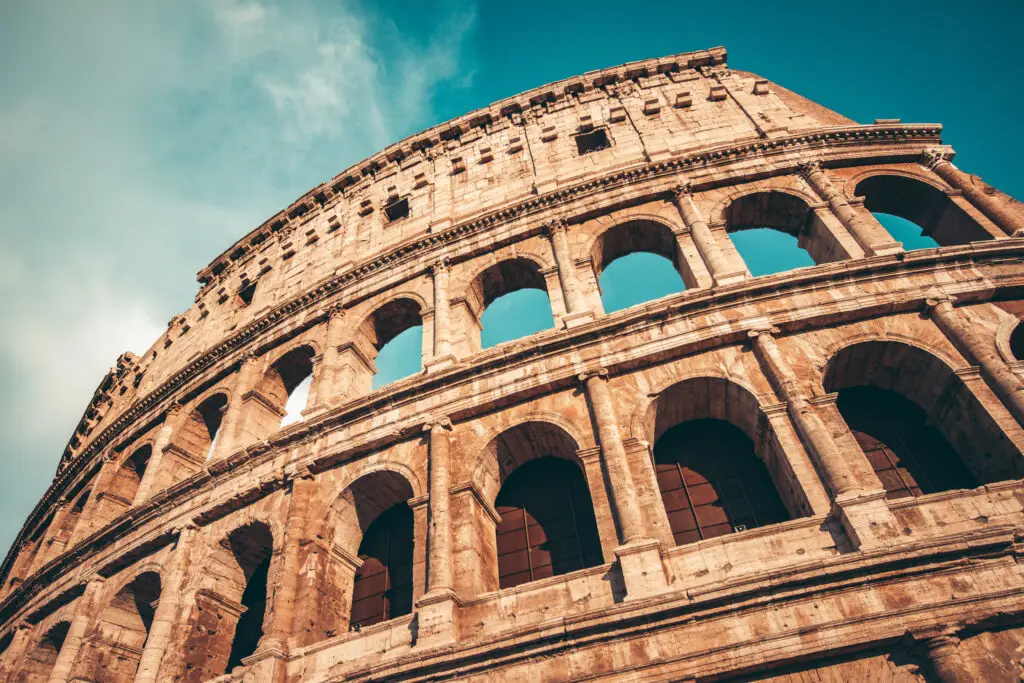 Roman Colosseum exterior showing four tiers of arches stacked vertically, illustrating how keystone architecture creates enduring strength by building layer upon layer over time