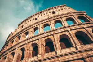 Roman Colosseum exterior showing four tiers of arches stacked vertically, illustrating how keystone architecture creates enduring strength by building layer upon layer over time