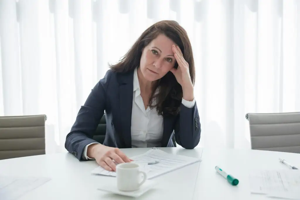 Stressed CEO at an overflowing desk with 60-hour work week